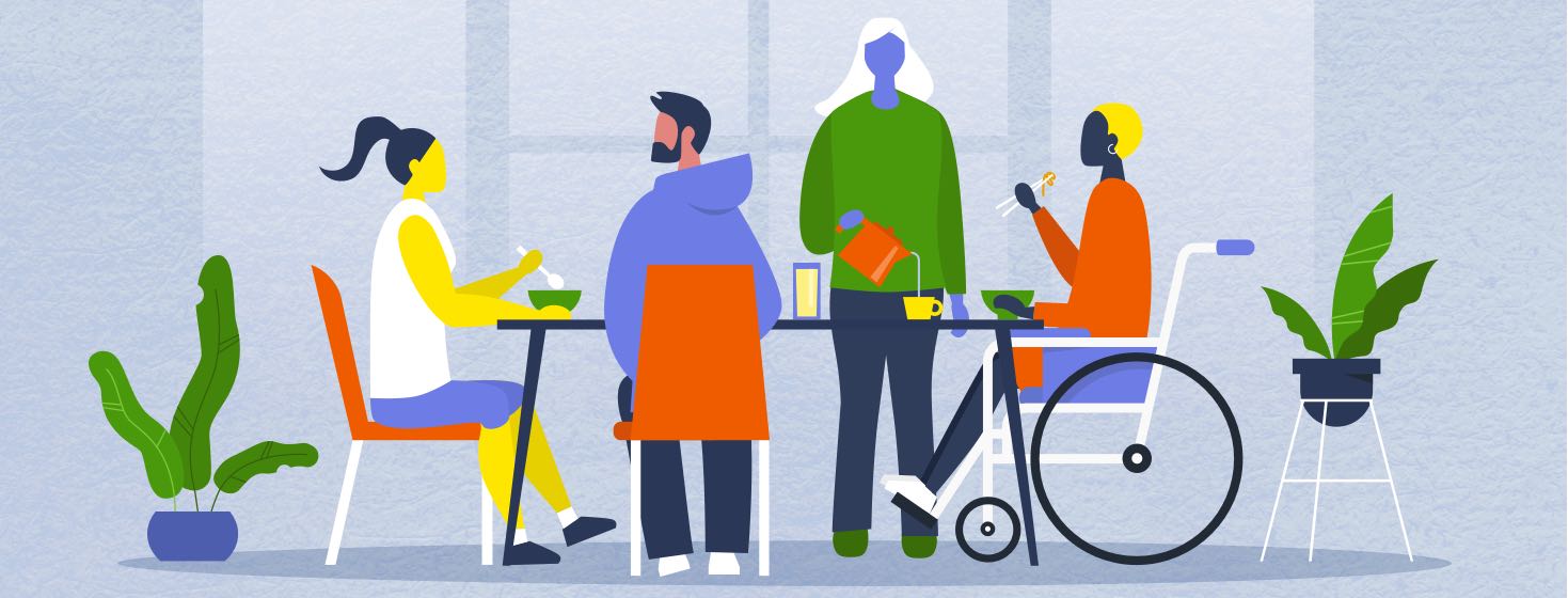 A group of differently abled people sitting a a table eating together.