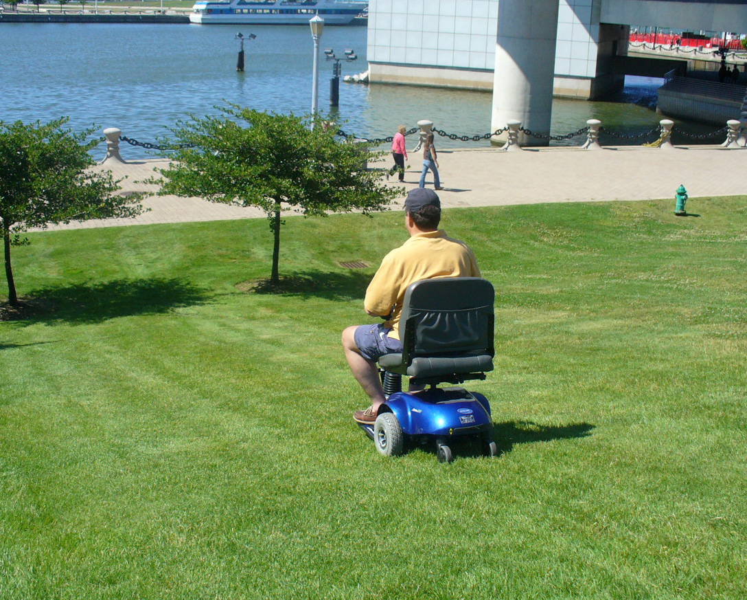 Mitch riding on a lawn in a motorized scooter