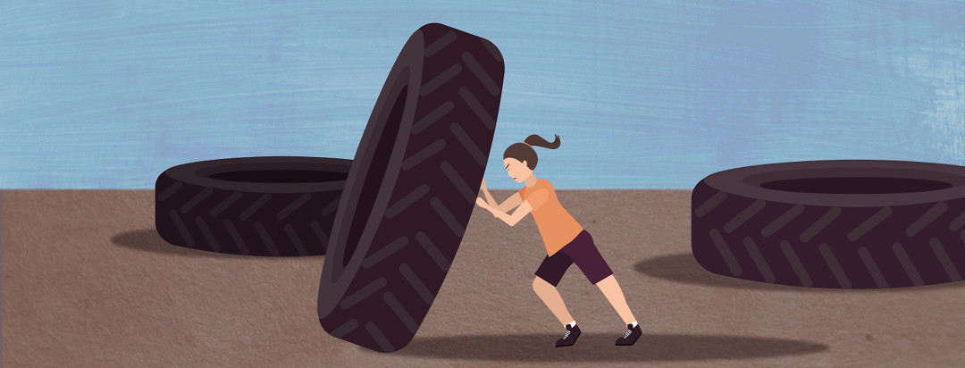A woman trying really hard to push a tire that is bigger than her.