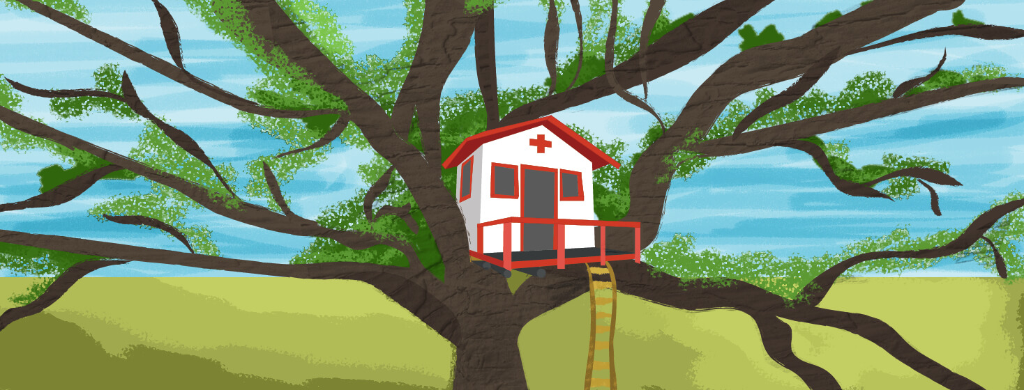 A children's treehouse is nestled in a large tree in a field. The house is decorated like a hospital.
