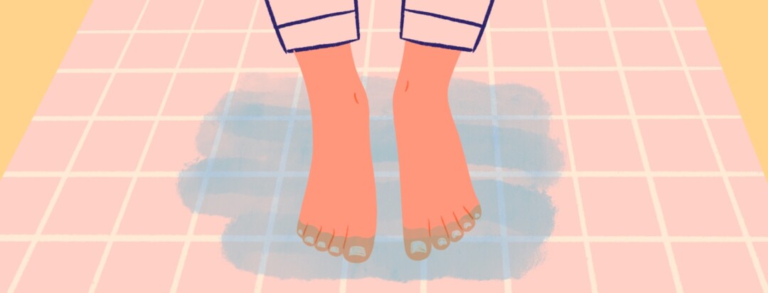 A pair of feet on a wet tile floor